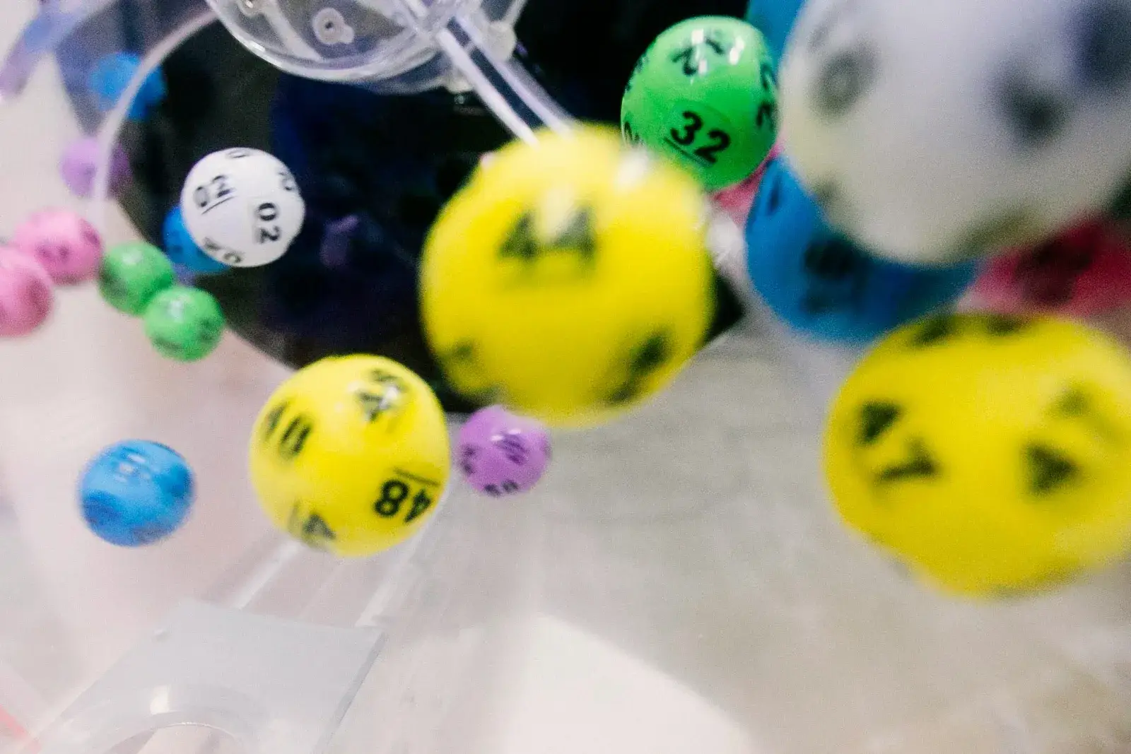 Colourful numbered bingo balls tumbling inside a draw drum