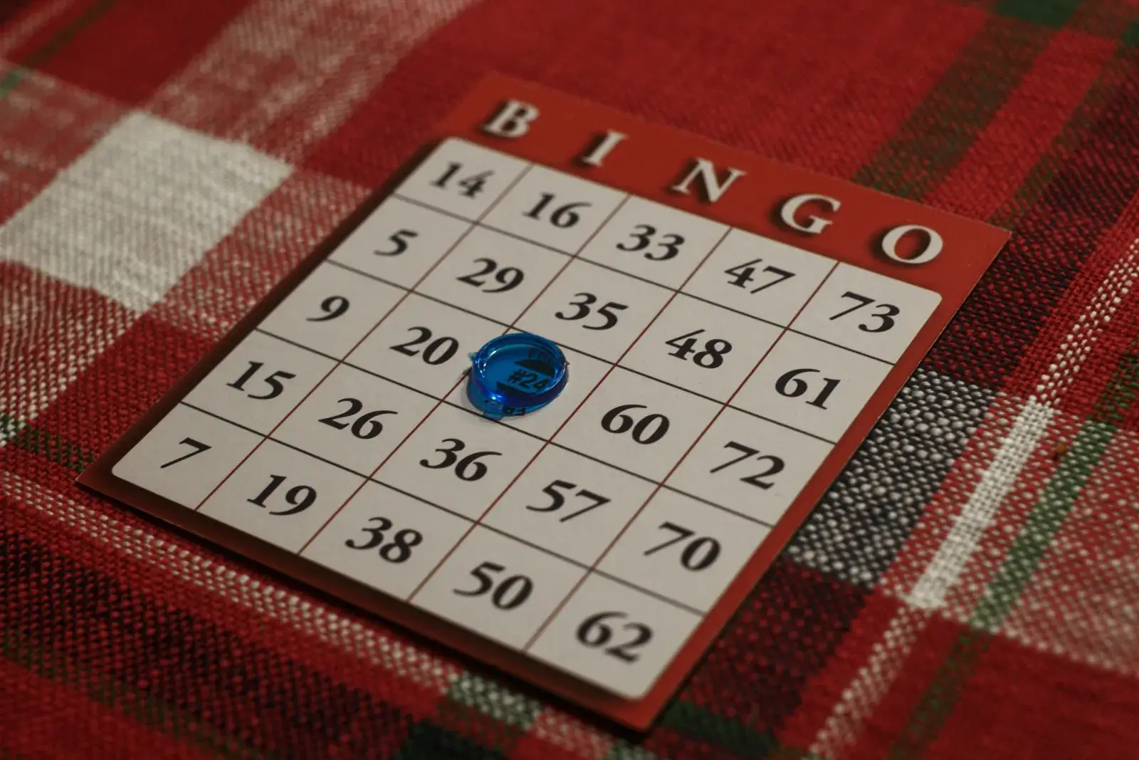 Physical bingo card with numbers and a dauber marker resting on it