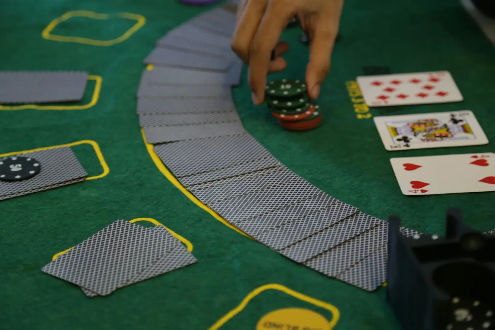 Playing cards and casino chips arranged on a blackjack table felt
