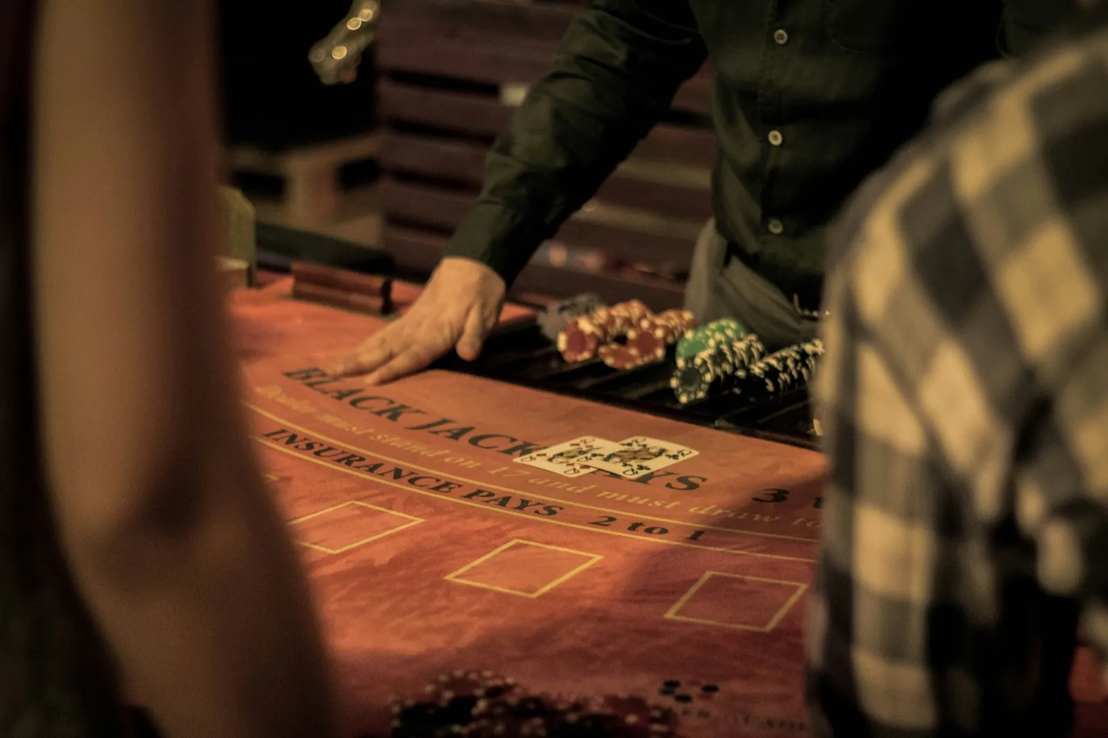 Dealer laying out cards at a live blackjack table with chip trays and betting spots